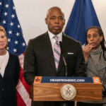People standing at a podium with flags behind them.