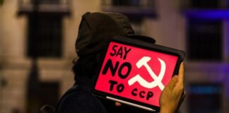 Person holding a protest sign that reads Say NO to CCP with a communist symbol