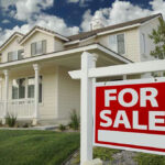 House with For Sale sign in front yard.