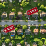 Aerial view of neighborhood with Sold signs on houses.