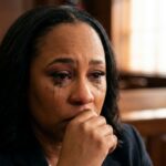 A woman in a courtroom visibly upset with tears streaming down her face
