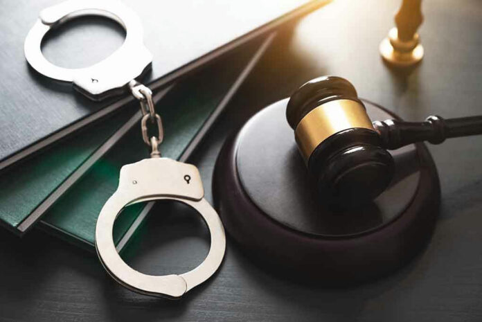 Handcuffs, gavel, and books on a table.