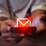 Person holding phone with email alert notification.
