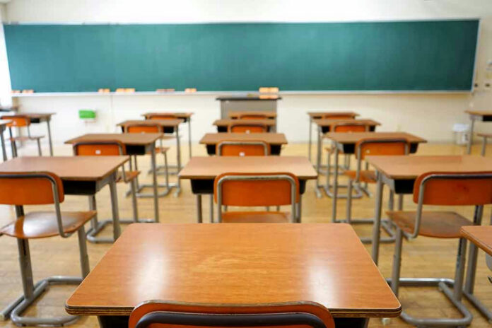 356921618 Empty classroom with wooden desks and chalkboard.