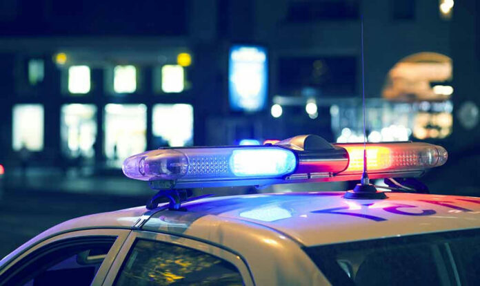 582908293-1 Police car with flashing lights at night.