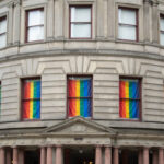 Historic building with rainbow flags displayed in the windows