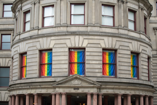 Historic building with rainbow flags displayed in the windows