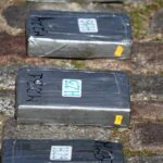 Gray taped packages lying on a cobblestone surface