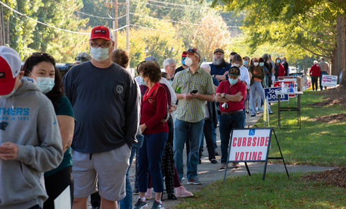 People standing in line for curbside voting on an autumn day