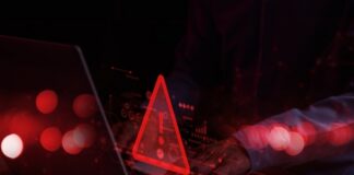 A person typing on a laptop with a red warning symbol overlay