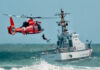 Coast Guard training with helicopter and boat in rough seas.