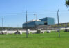 Chain-link fence in front of a large modern office complex