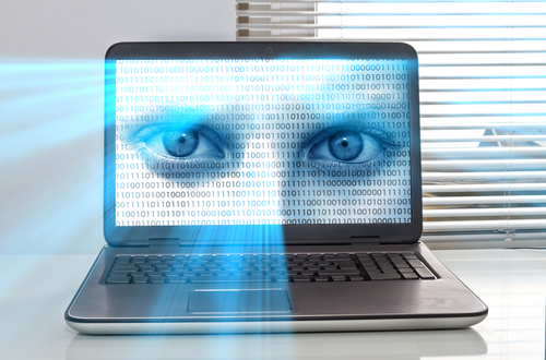 A laptop screen displaying a pair of blue eyes overlaid with binary code