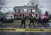FBI agents at a crime scene outside a house with police vehicles and caution tape