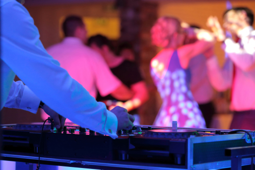 DJ playing music at a lively dance event.