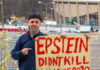 Man holding "Epstein didn't kill himself 2020" sign.