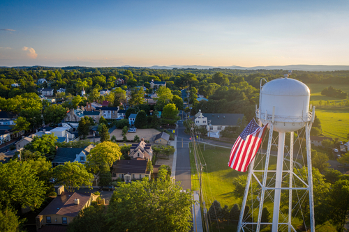 Water tower with American flag overlooking a small town.