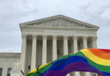 Supreme Court building with rainbow flag in foreground.