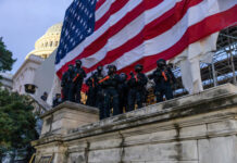 Police in riot gear near U.S. Capitol building.